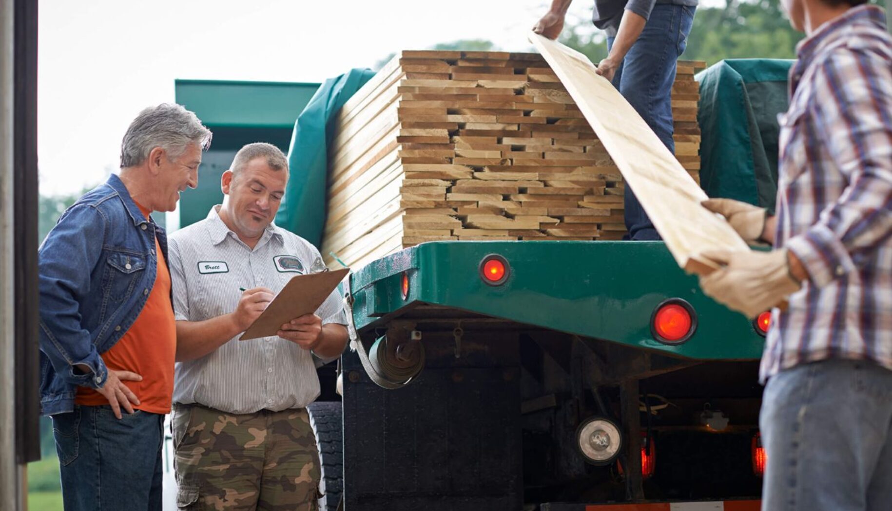 Keim delivery person and workers unloading lumber