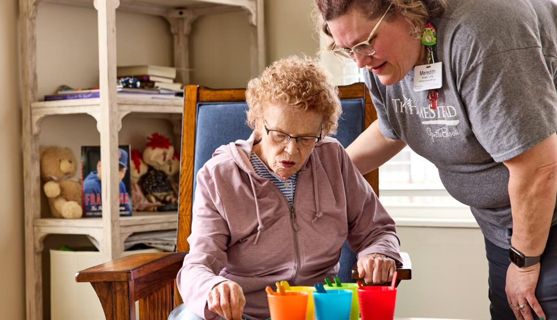 A stock photo of a woman caring for an elderly woman in a rocking chair