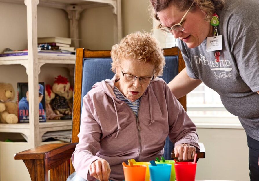 A stock photo of a woman caring for an elderly woman in a rocking chair