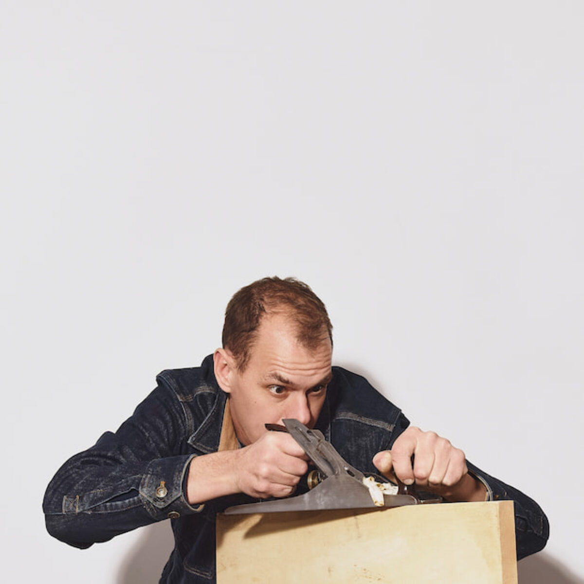 Seth Teter planing a piece of wood with a hand plane
