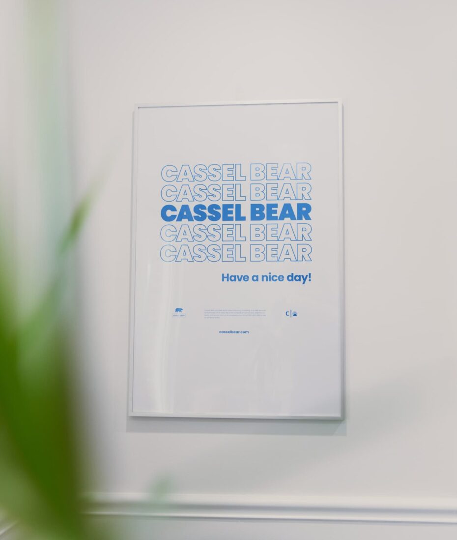 Akron Marketing Agency office wall display featuring a Cassel Bear poster that reads “Have a nice day!”