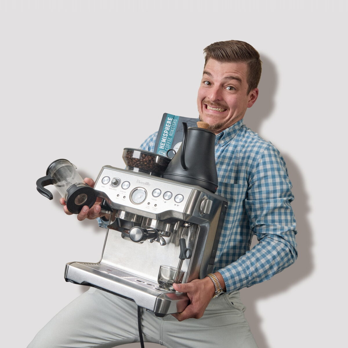 Seth Marana holding an espresso machine and coffee gear